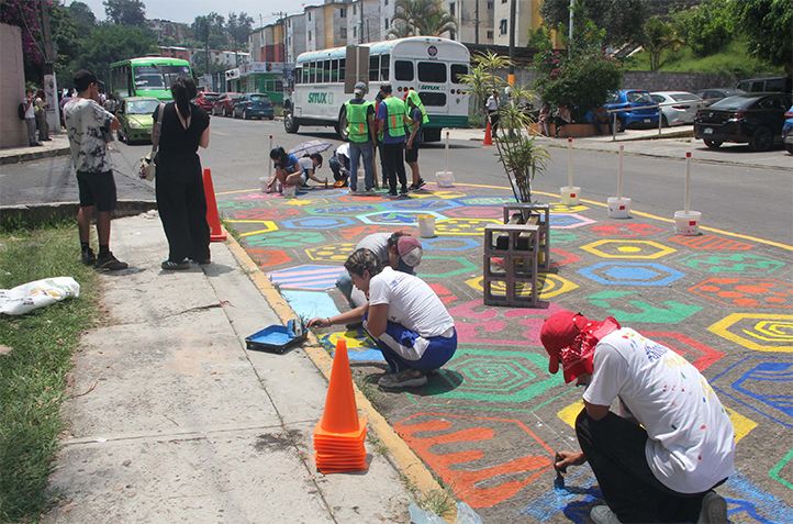 Estudiantes de la UV pintan orejas peatonales en un cruce peatonal de Xalapa