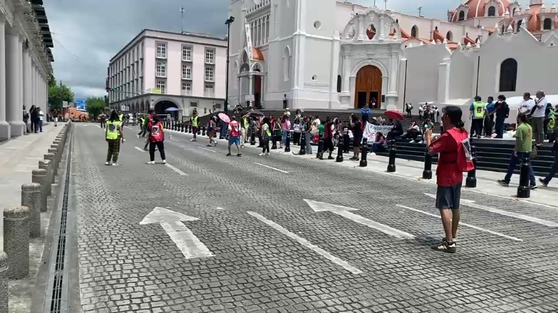 Integrantes de colectivos juegan futbol en la calle Enríquez con fotografías de desaparecidos en la espalda
