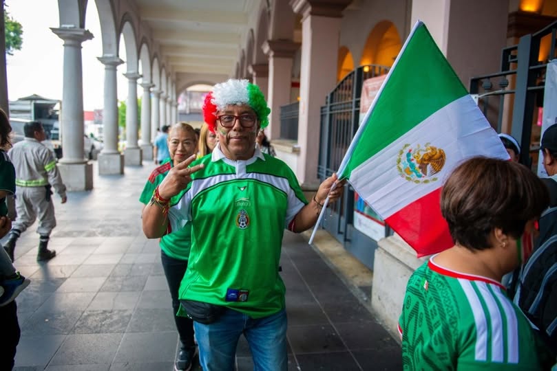 Familias y autoridades municipales en la explanada del Palacio Municipal viendo el partido de México contra Corea del Sur