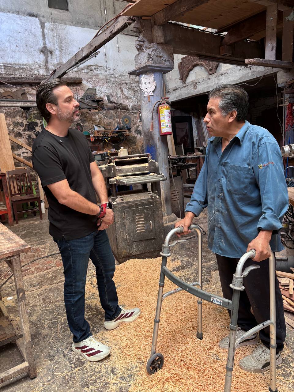 Tato Vega y el carpintero Joel Romero en la entrada del taller